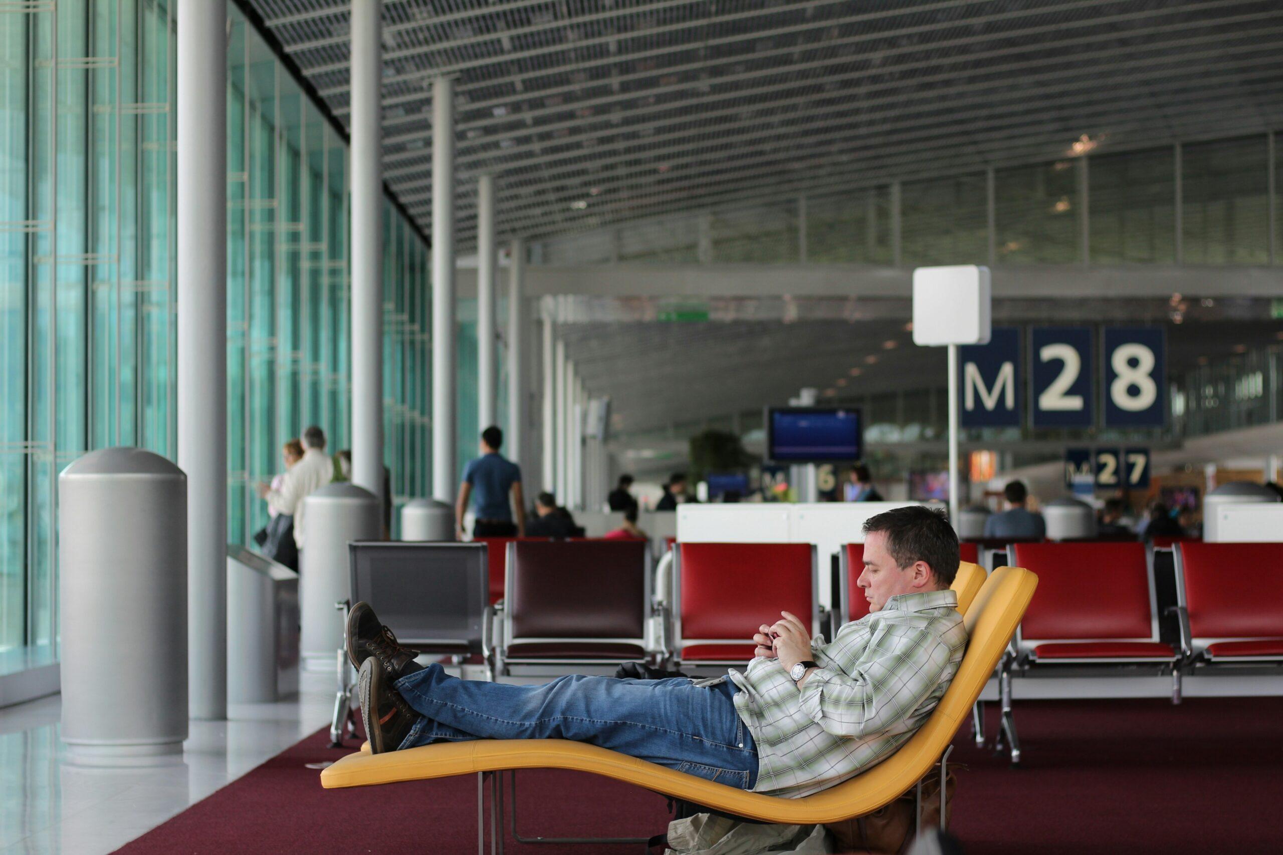A person struggling with large, unwieldy surfboard luggage at an airport.