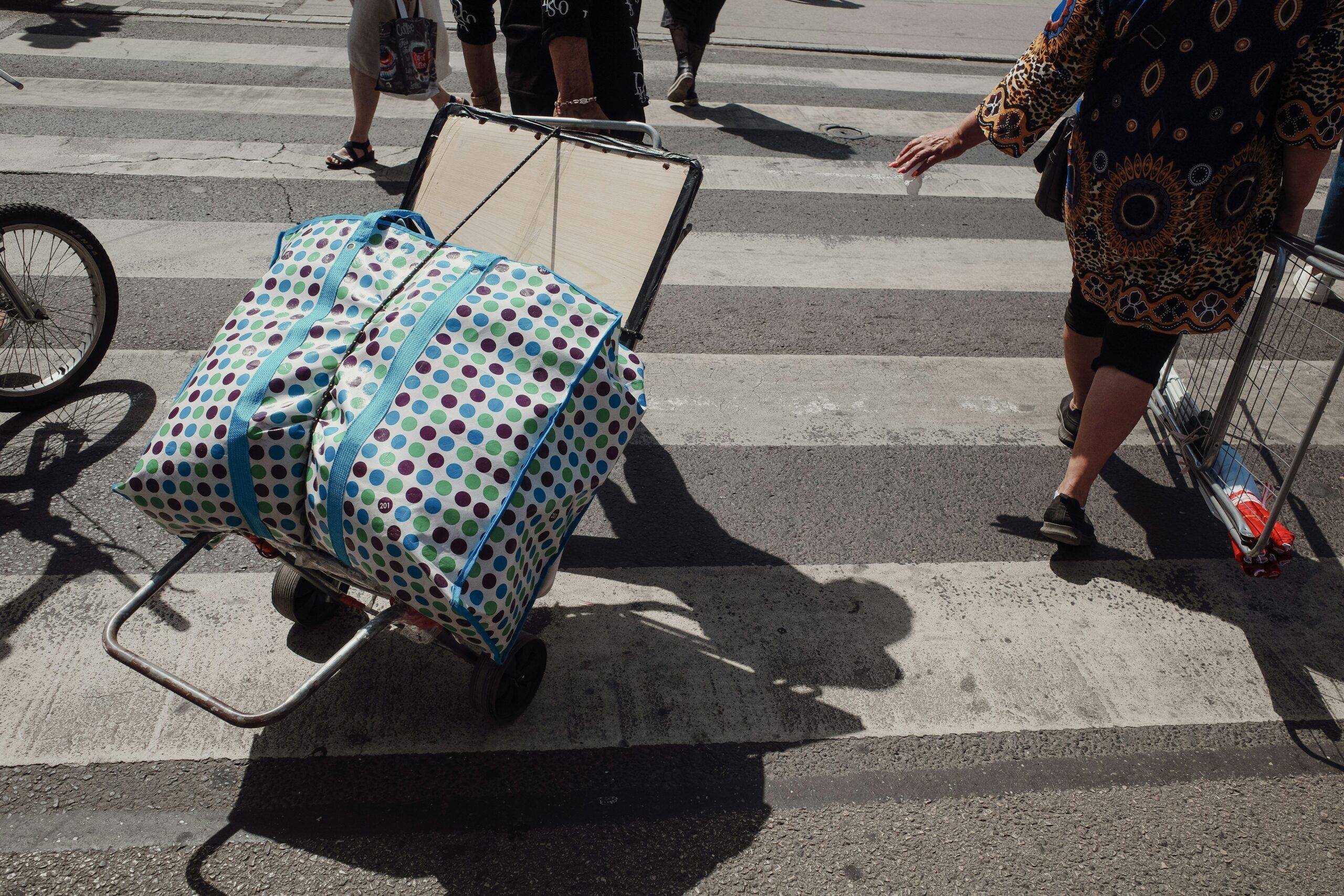 Man struggling to pull heavy surfboard luggage at an airport