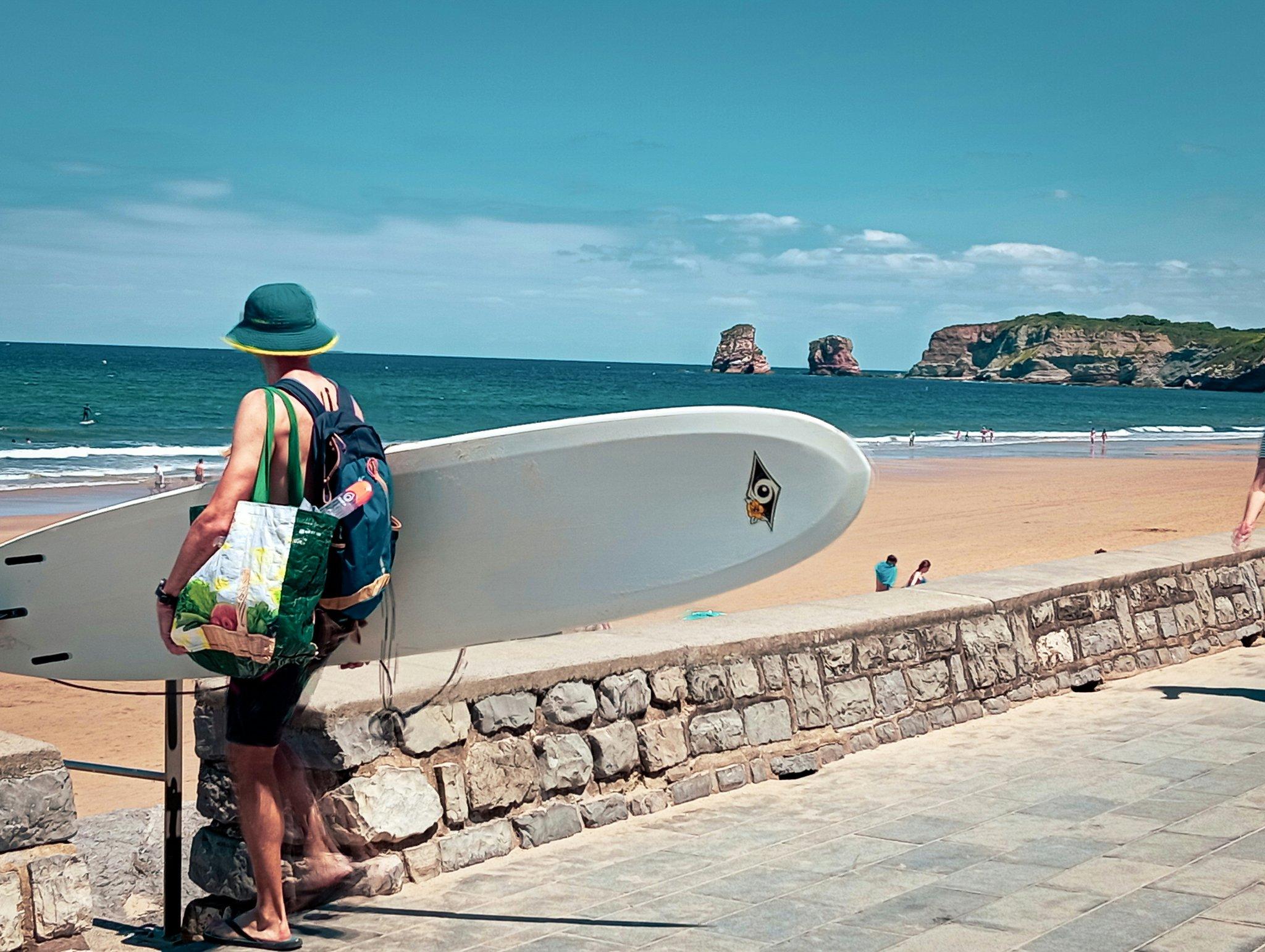 Happy surfer holding his undamaged surfboard at the beach