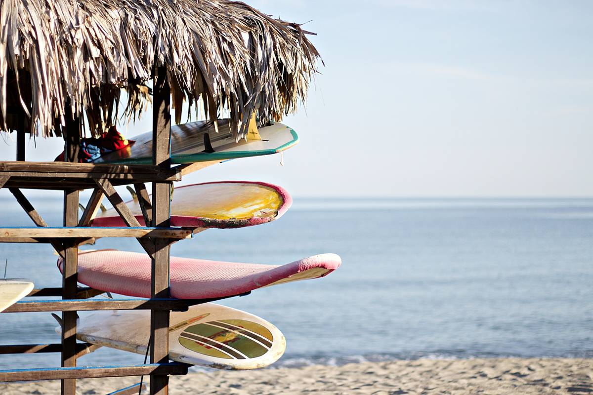 Step-by-step images of attaching a wave shield pad to a surfboard.