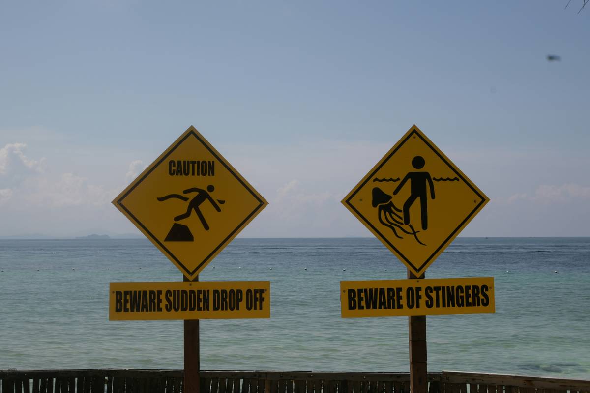 A damaged surfboard at airport baggage claim showcasing cracks and broken fins
