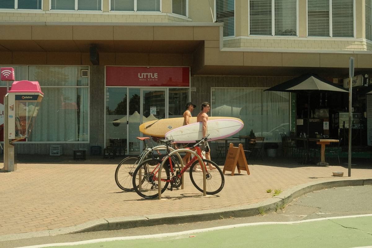 Surfer holding a custom surf transport kit filled with protective gear