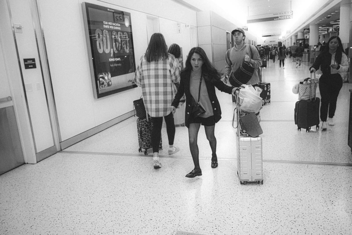 Surfer holding a damaged surfboard at the airport