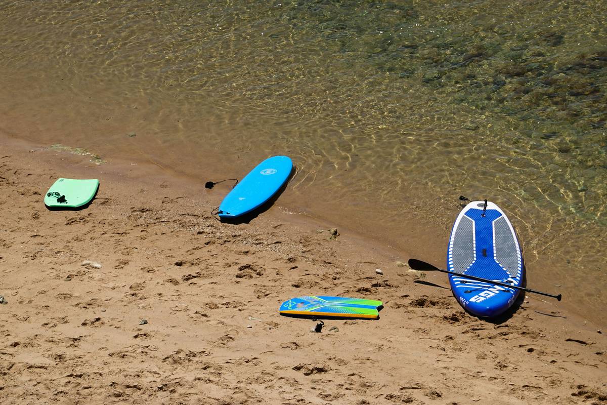 A happy traveler posing next to her intact surfboard after landing safely.