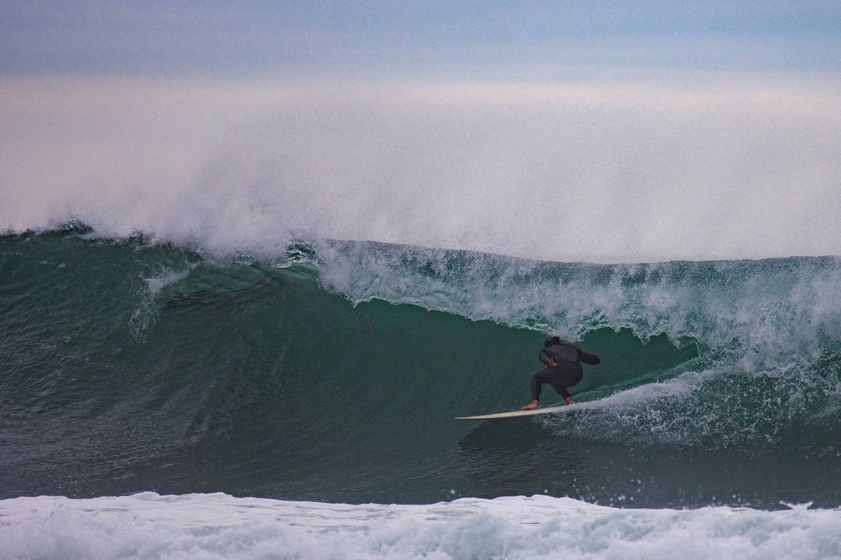 Diagram illustrating layers of a premium surfboard bag, including foam padding and waterproof material.