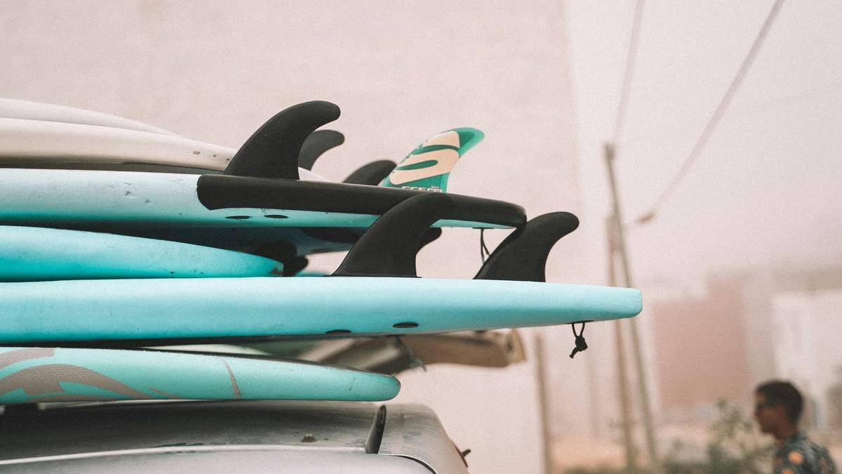 Infographic showing common surfboard damage types caused by poor storage: delamination from moisture, pressure dings from improper leaning, UV yellowing on deck