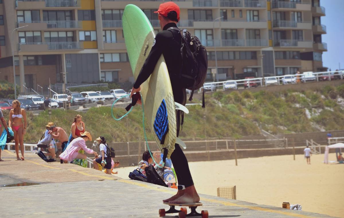 Comparison chart of Wave Shield surfboard bags showing weight, wheel type, padding thickness, and airport transit time across Velocity Pro, Nomad, and Coast models